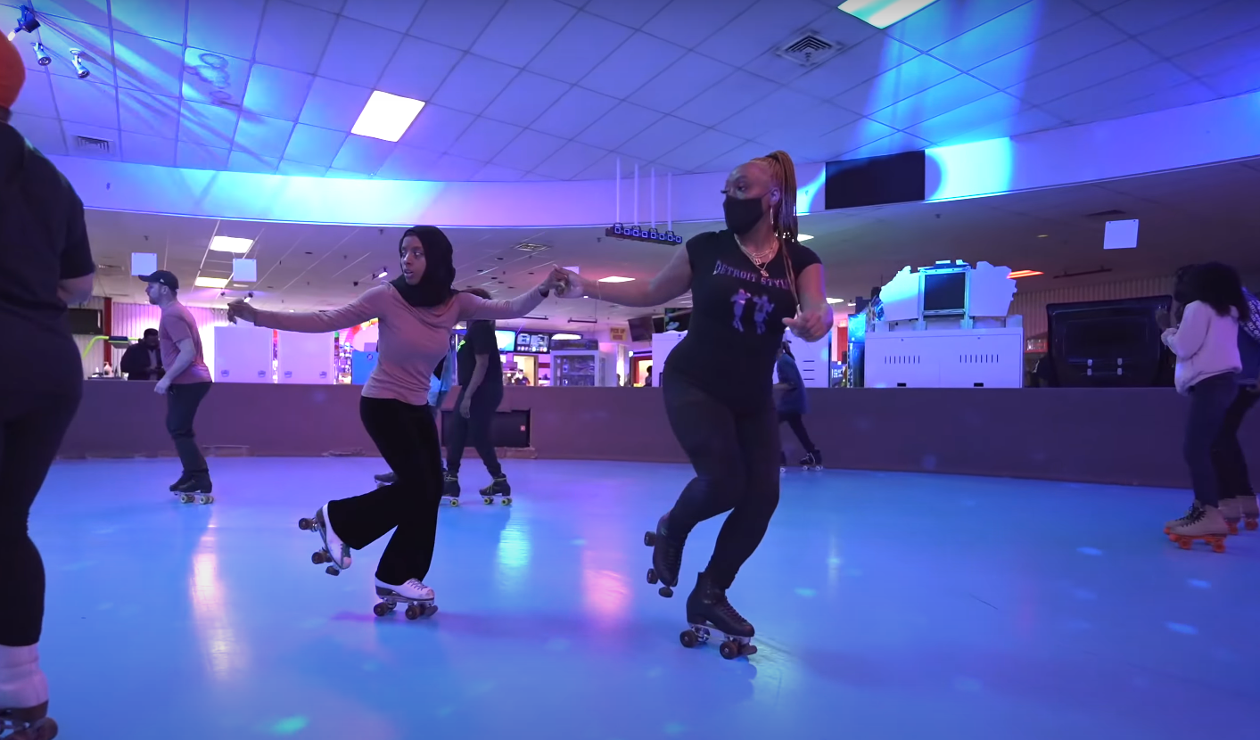 Women holding hands and doing a roller skate pivot together