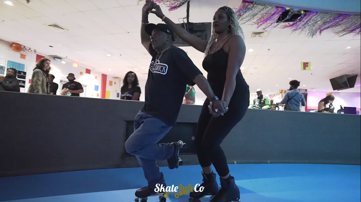 A man and a woman holding each other ands and skating